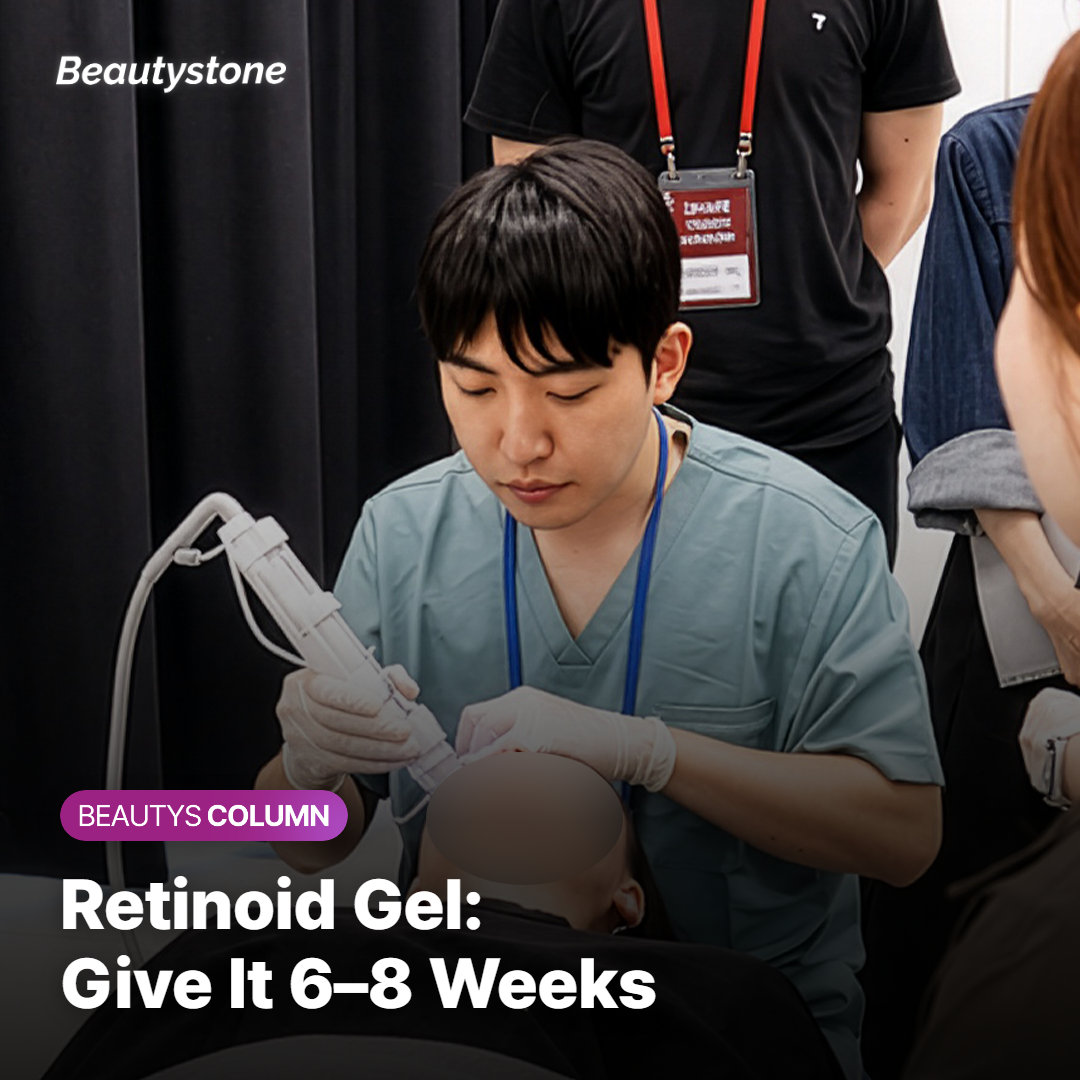 A pea-sized amount of retinoid gel on a fingertip beside a facial wash